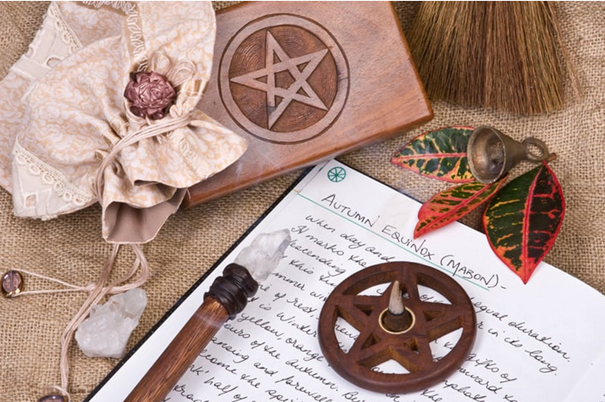 Ritueel beeld bij Mabon – boekje, kristal en herfstblaadjes als symbool voor oogst en balans